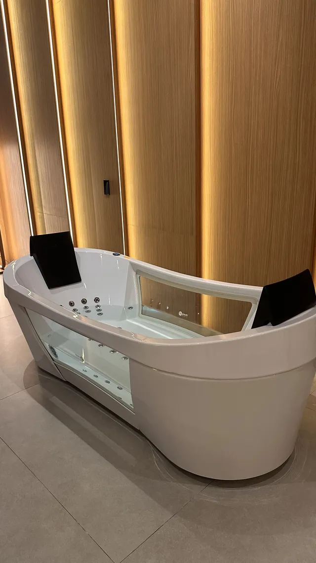 Banheira de hidromassagem branca em banheiro com painéis de madeira e fitas de LED